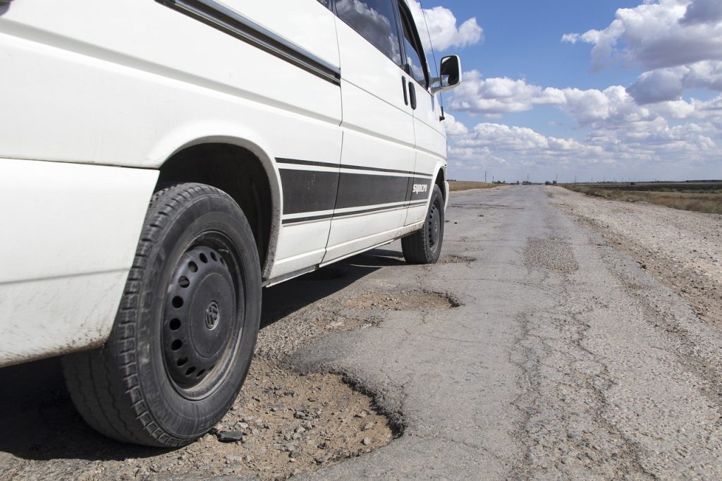 Car driving over a pothole